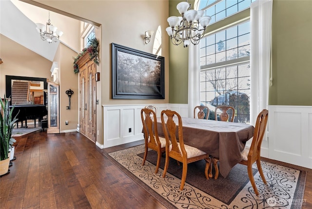 dining room with high vaulted ceiling, dark wood-type flooring, and a chandelier