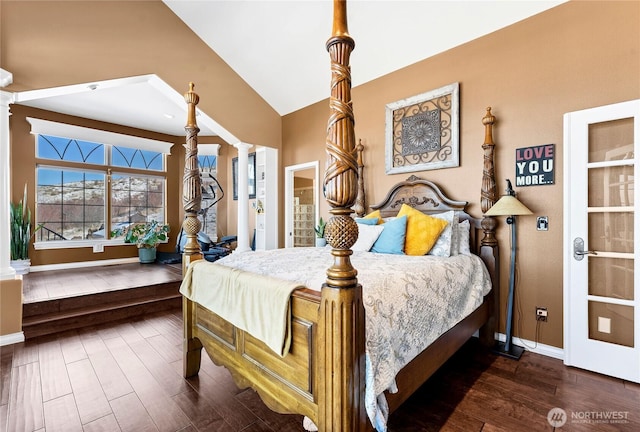 bedroom featuring decorative columns, lofted ceiling, and dark hardwood / wood-style floors