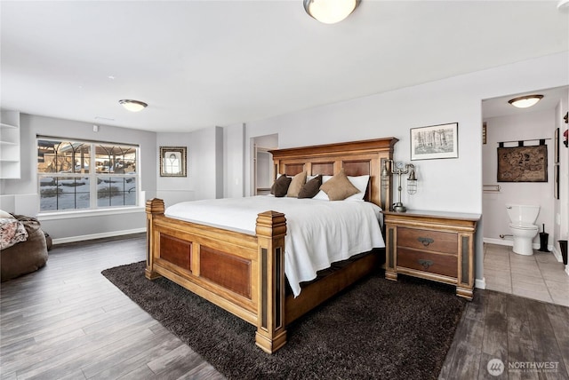 bedroom with ensuite bathroom and dark hardwood / wood-style flooring