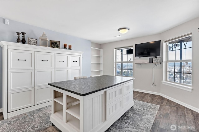 kitchen featuring a kitchen island, dark wood-type flooring, and white cabinets