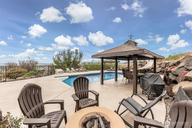 view of pool featuring a gazebo, a grill, a patio area, and a fire pit