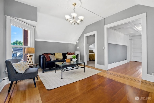 living room featuring vaulted ceiling, a chandelier, and hardwood / wood-style floors