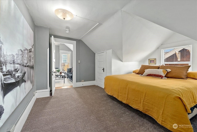 bedroom with dark carpet and lofted ceiling