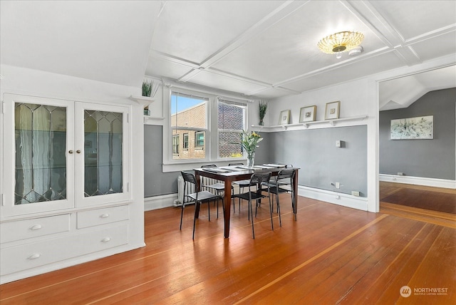 dining area featuring coffered ceiling and hardwood / wood-style floors