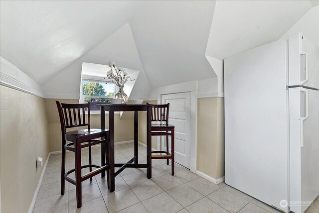 additional living space with light tile patterned flooring and vaulted ceiling