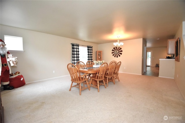 dining space featuring an inviting chandelier and carpet flooring