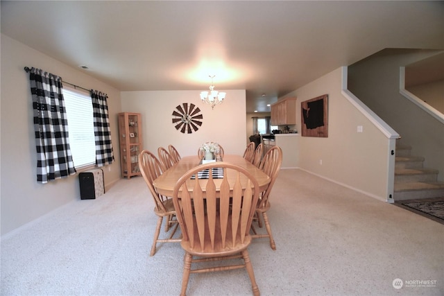 dining area featuring light carpet, a wealth of natural light, and a notable chandelier