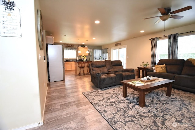 living room featuring ceiling fan and light hardwood / wood-style floors