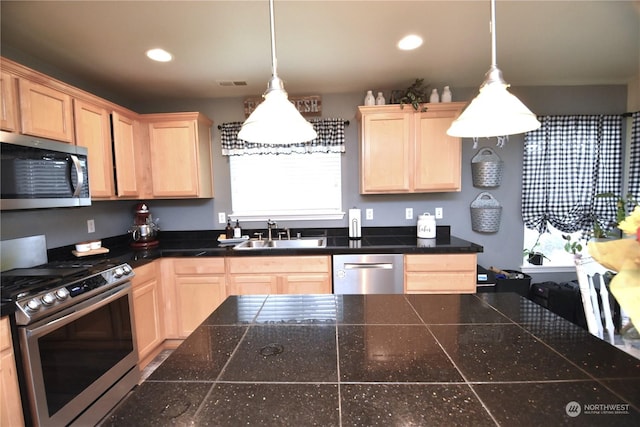 kitchen featuring stainless steel appliances, sink, pendant lighting, and light brown cabinets