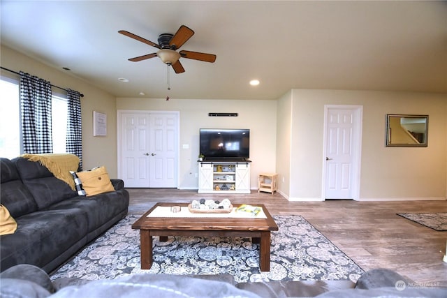 living room with wood-type flooring and ceiling fan