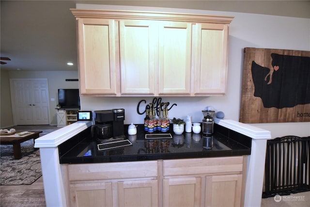 kitchen with light brown cabinets, light hardwood / wood-style floors, and kitchen peninsula