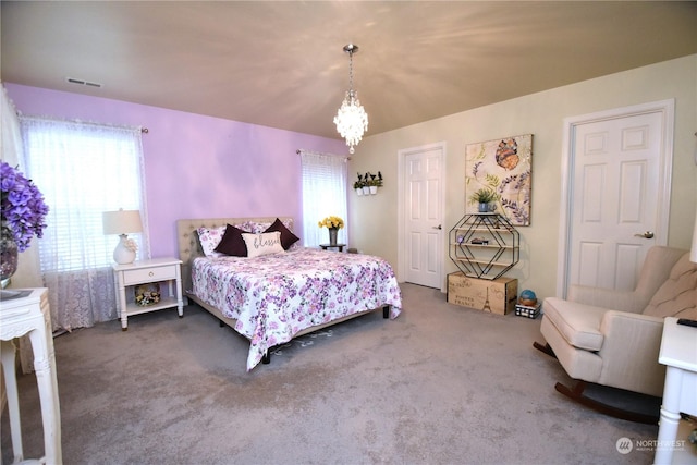 carpeted bedroom with an inviting chandelier