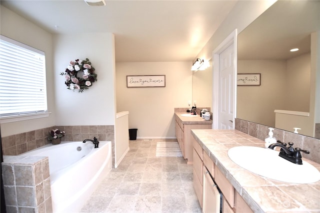 bathroom with a tub to relax in and vanity