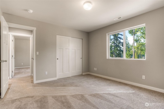 unfurnished bedroom featuring a closet and light carpet