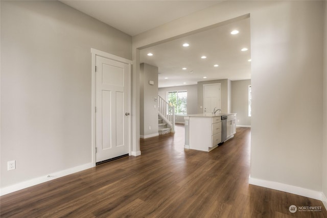 unfurnished living room featuring sink and dark hardwood / wood-style floors