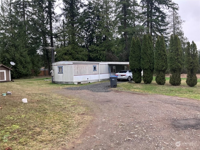 manufactured / mobile home featuring an outbuilding, crawl space, driveway, and a front yard