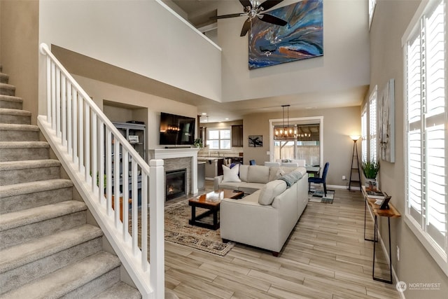 living room with a towering ceiling, light hardwood / wood-style floors, and a wealth of natural light