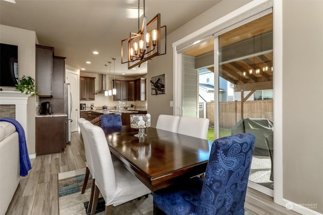 dining area with light hardwood / wood-style floors and a chandelier