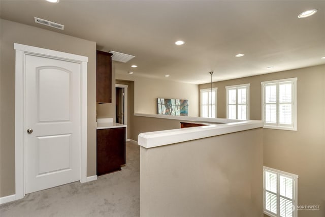 hallway with light colored carpet