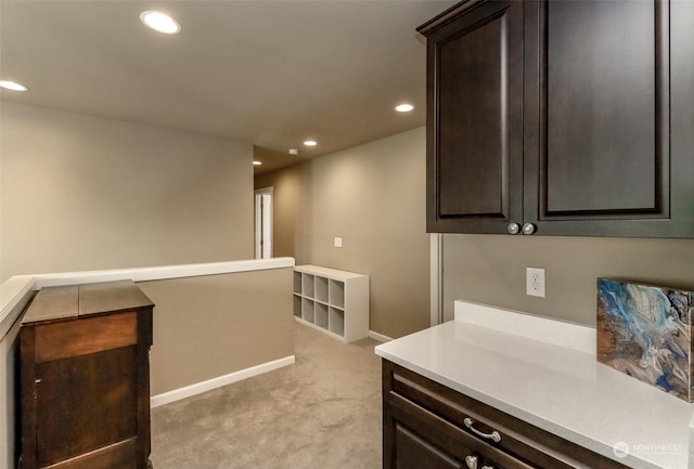 bar featuring light colored carpet and dark brown cabinets