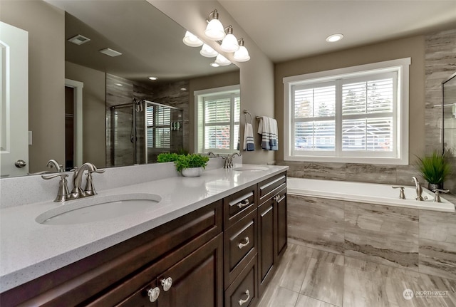 bathroom featuring vanity and independent shower and bath