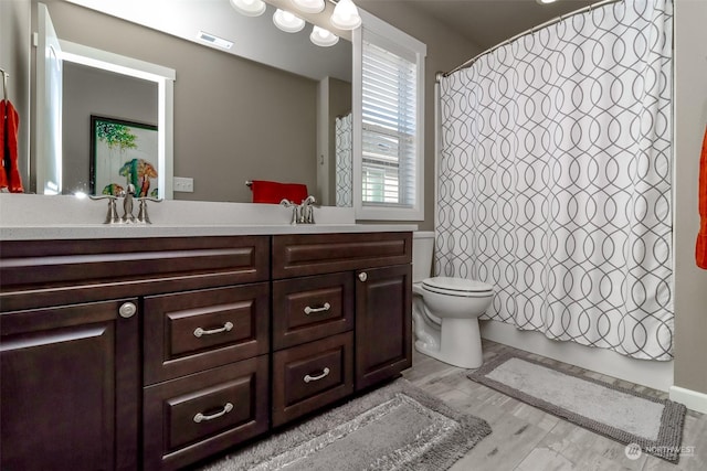 bathroom with a shower with shower curtain, vanity, toilet, and hardwood / wood-style floors