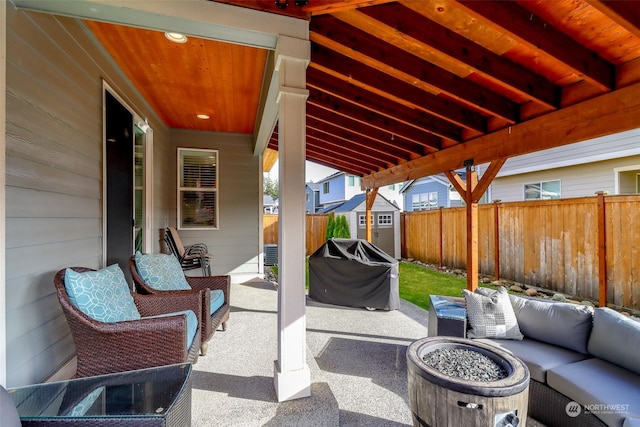 view of patio / terrace with area for grilling, an outdoor living space with a fire pit, and a storage unit