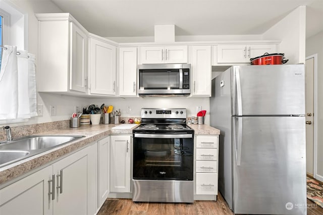 kitchen featuring light hardwood / wood-style floors, sink, white cabinetry, and stainless steel appliances