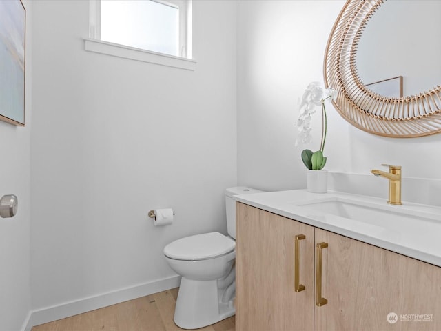 bathroom featuring wood-type flooring, toilet, and vanity