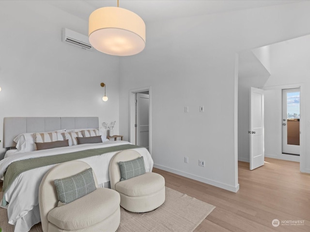 bedroom featuring a wall unit AC and light wood-type flooring