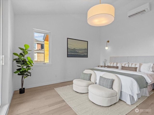 bedroom featuring a wall mounted AC, light hardwood / wood-style flooring, and vaulted ceiling