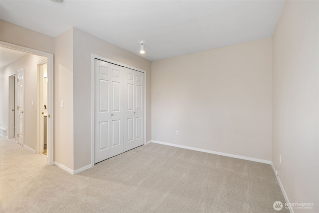 unfurnished bedroom featuring light carpet and a closet