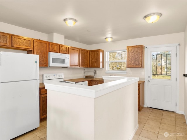 kitchen featuring a center island, light tile patterned floors, and white appliances