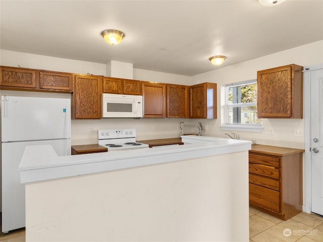 kitchen featuring light tile patterned flooring and white appliances