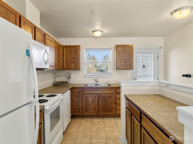 kitchen featuring sink, light tile patterned floors, and white appliances