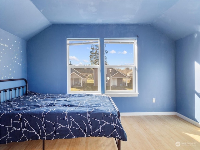 bedroom featuring hardwood / wood-style flooring and vaulted ceiling