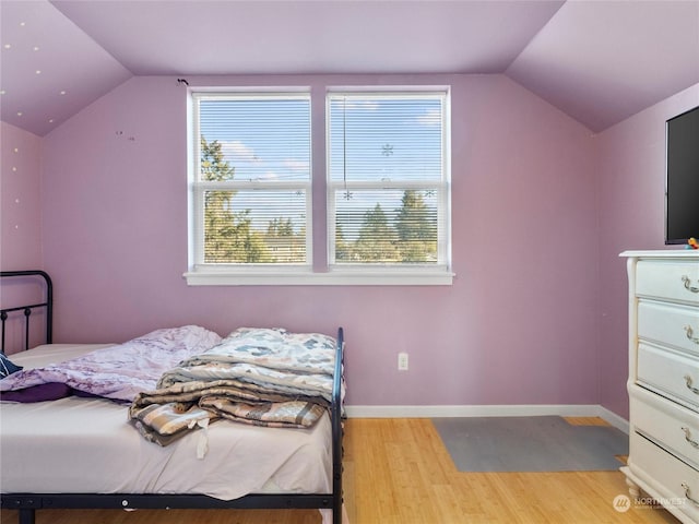 bedroom with vaulted ceiling and light wood-type flooring