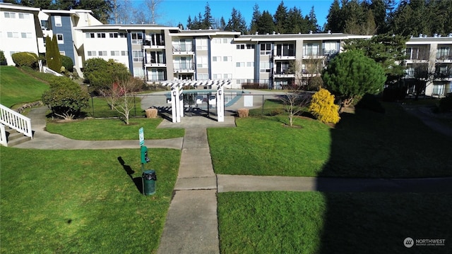 view of home's community featuring a yard and a pergola