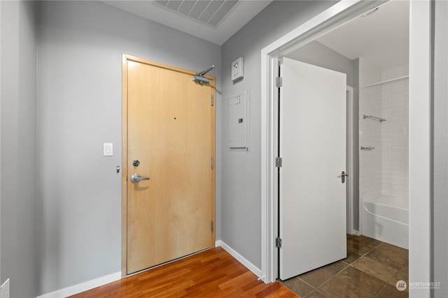 interior space with tile patterned floors and electric panel