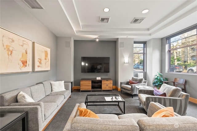 carpeted living room featuring a tray ceiling