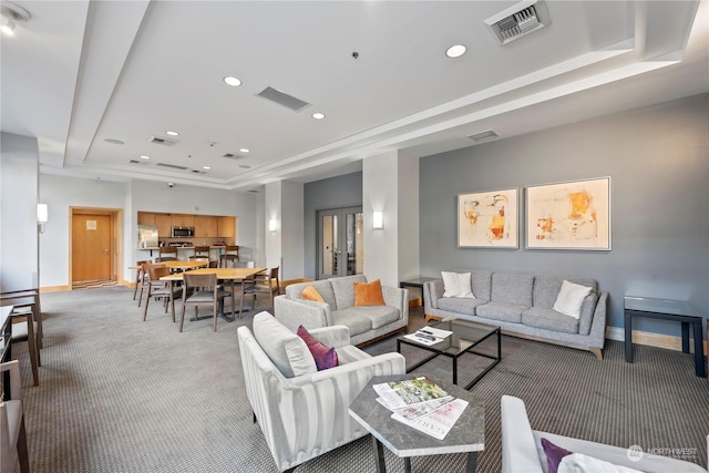 carpeted living room featuring a raised ceiling