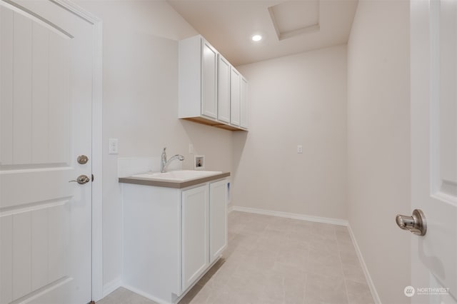 laundry room featuring washer hookup, sink, light tile patterned floors, and cabinets