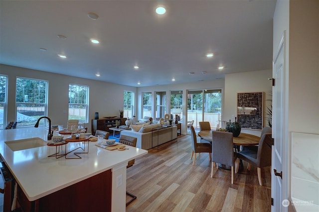 kitchen featuring a kitchen bar, sink, and light wood-type flooring