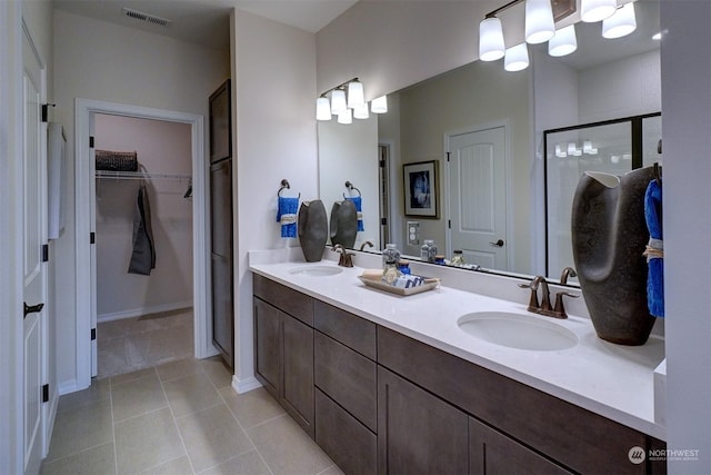 bathroom featuring tile patterned flooring, vanity, and a shower with shower door