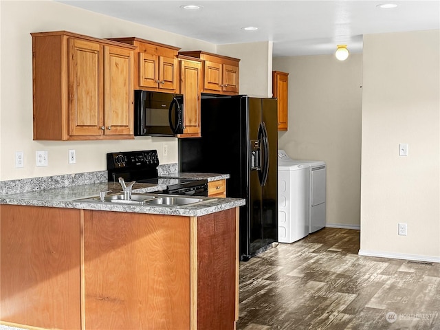 kitchen with hardwood / wood-style floors, kitchen peninsula, washer and clothes dryer, and black appliances