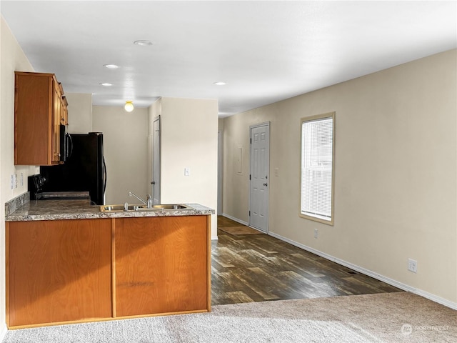 kitchen with stove, sink, and dark carpet