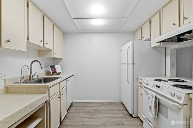 kitchen with cream cabinetry, sink, white appliances, and light hardwood / wood-style flooring