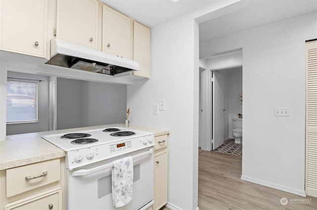 kitchen featuring cream cabinets, white electric range oven, and light hardwood / wood-style floors