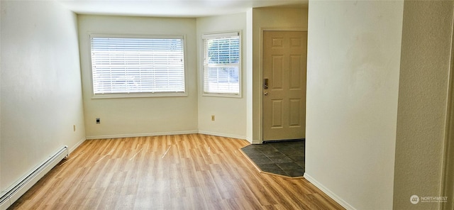 interior space featuring light wood-type flooring and a baseboard heating unit