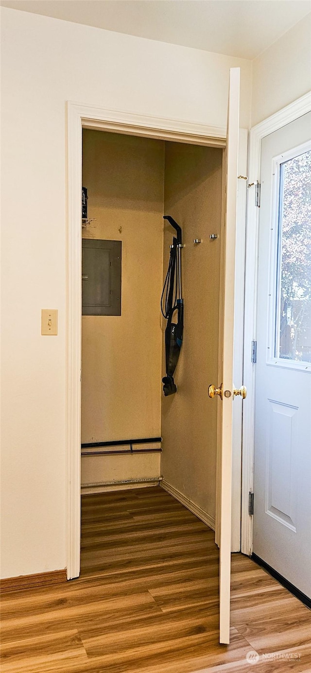 corridor featuring wood-type flooring and electric panel